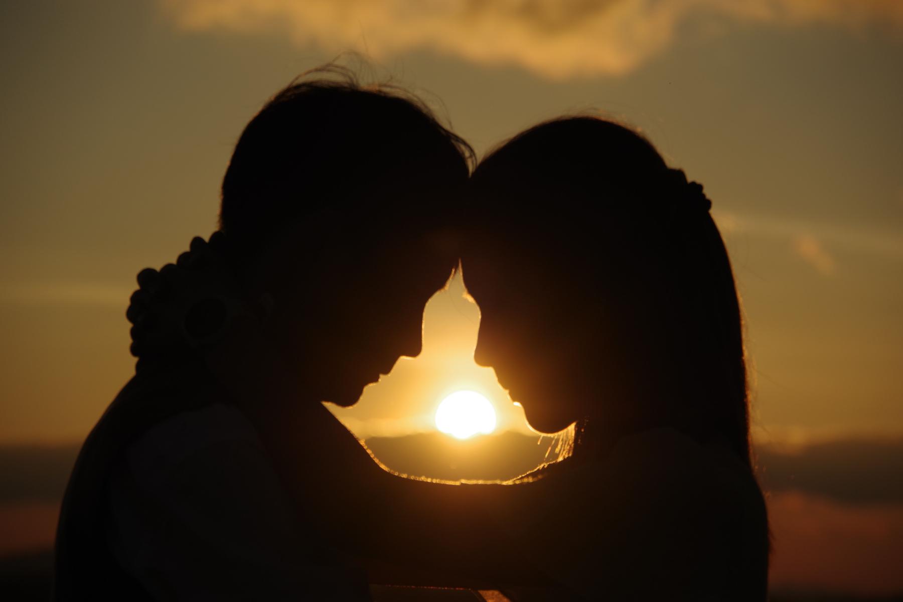 Silhouette von einem Paar im Sonnenuntergang Stirn an Stirn