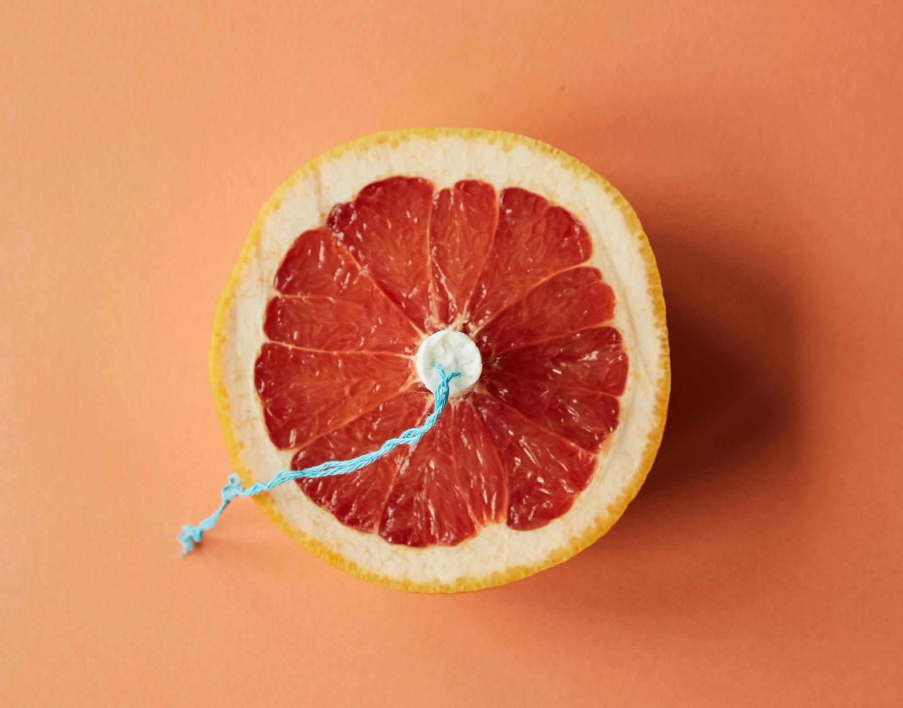 Halbe Grapefruit mit Tampon in der Mitte