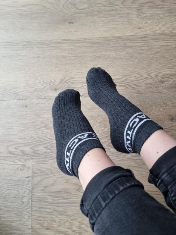 Getragene Socken von zarten Füßen